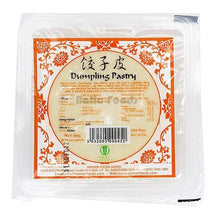 A packaged block of dumpling pastry (johszi pi) in a clear plastic bag with a prominent orange and beige label, shown against a plain white background.
